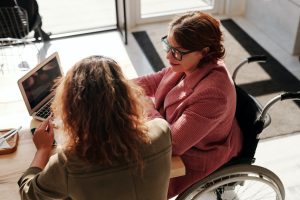 woman in wheelchair discussing in front of wallpaper