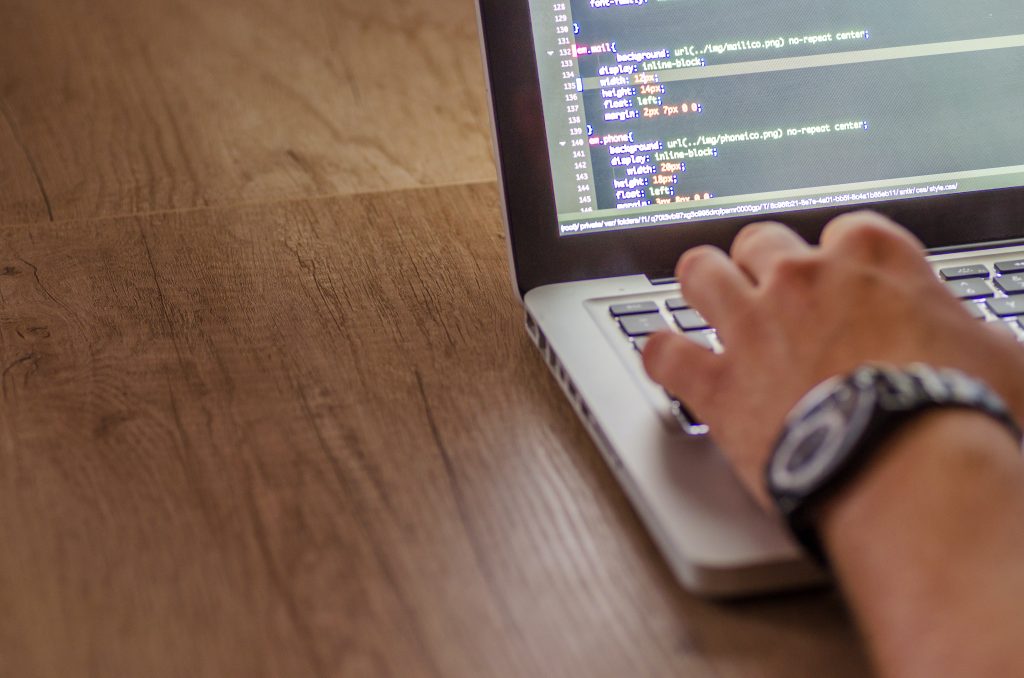 man typing code for website development