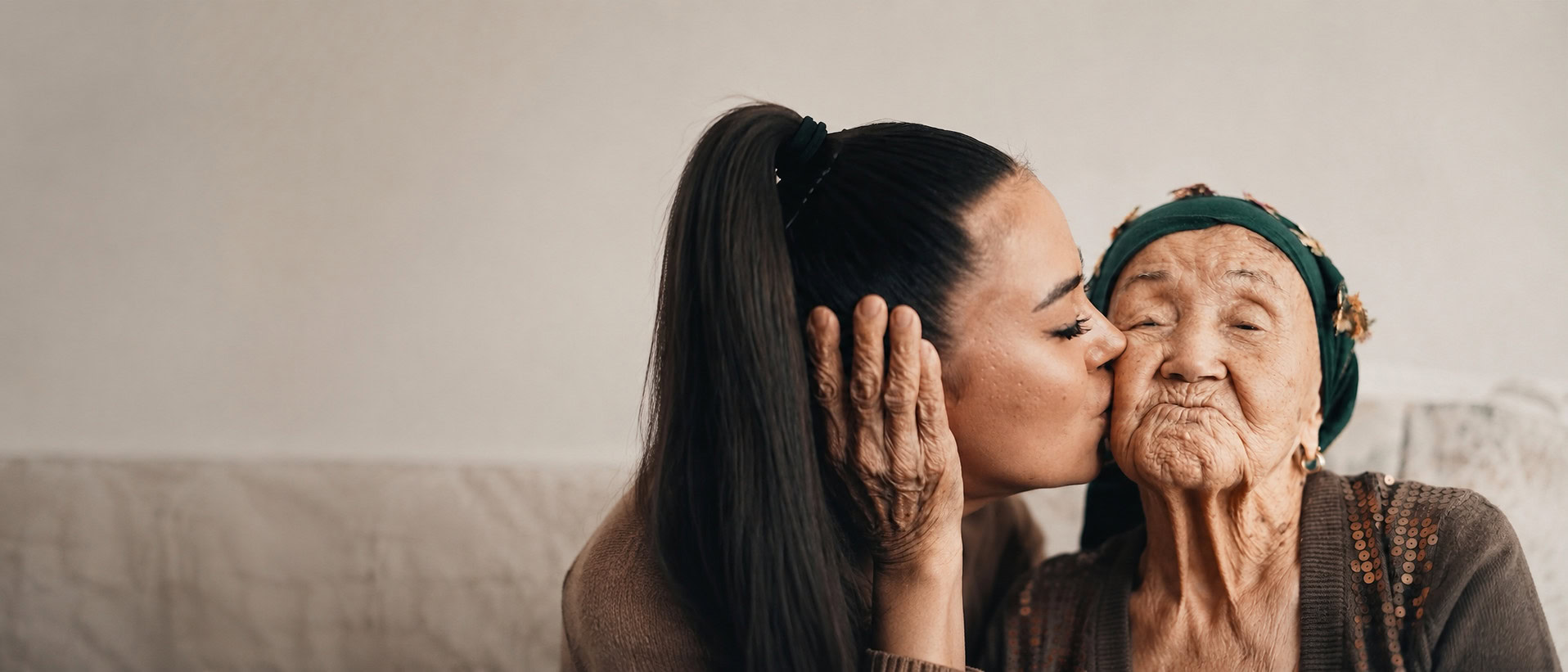 Woman kissing an elderly woman on the cheek at home-42 digital